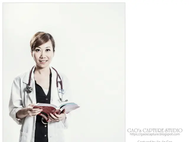 In this picture I can see a woman holding the book on the left side. There is the text on the right...