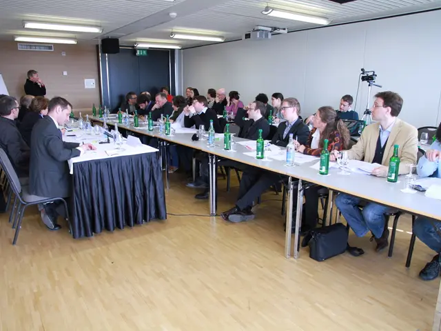 The picture is an office space. In the picture there are lot employees seated in the chairs in...