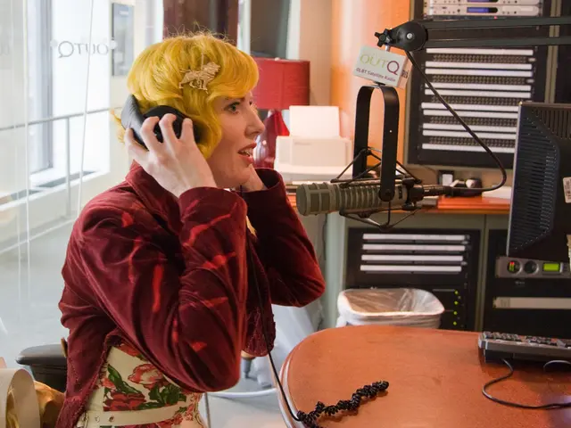 A girl is sitting and singing in the microphone.